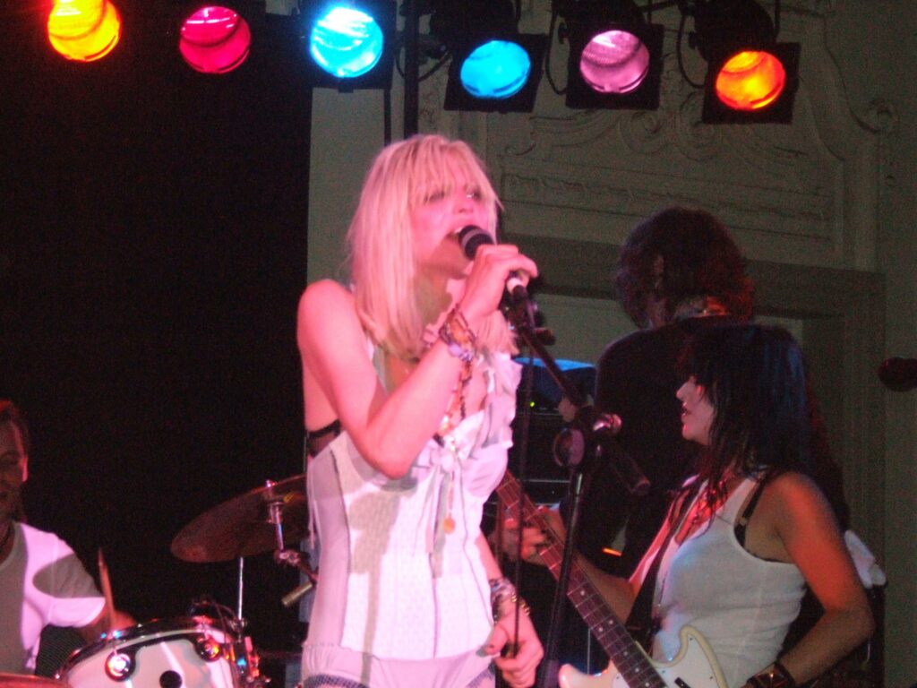 File:Courtney Love on stage.jpg - a woman singing into a microphone