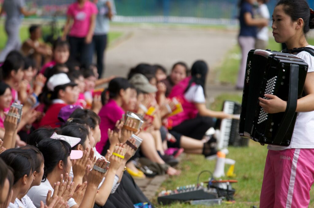 File:International Youth Day in North Korea 03.jpg - a group of people sitting on the grass