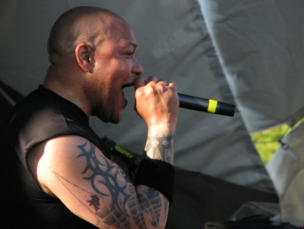 Howard jones of killswitch engage - a man with a tattoo on his arm singing into a microphone