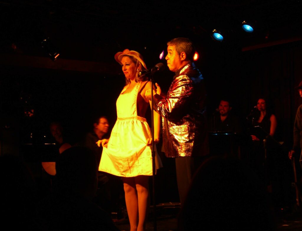 File:10.21.11LucioLessThanCubanByLuigiNovi7.jpg - a man and a woman singing into a microphone