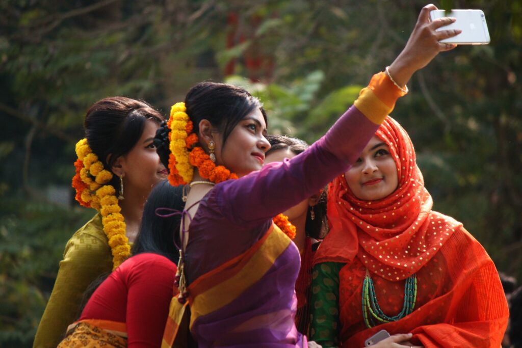 File:Bangladeshi girls taking Selfie at Pohela Falgun.jpg - a woman taking a picture