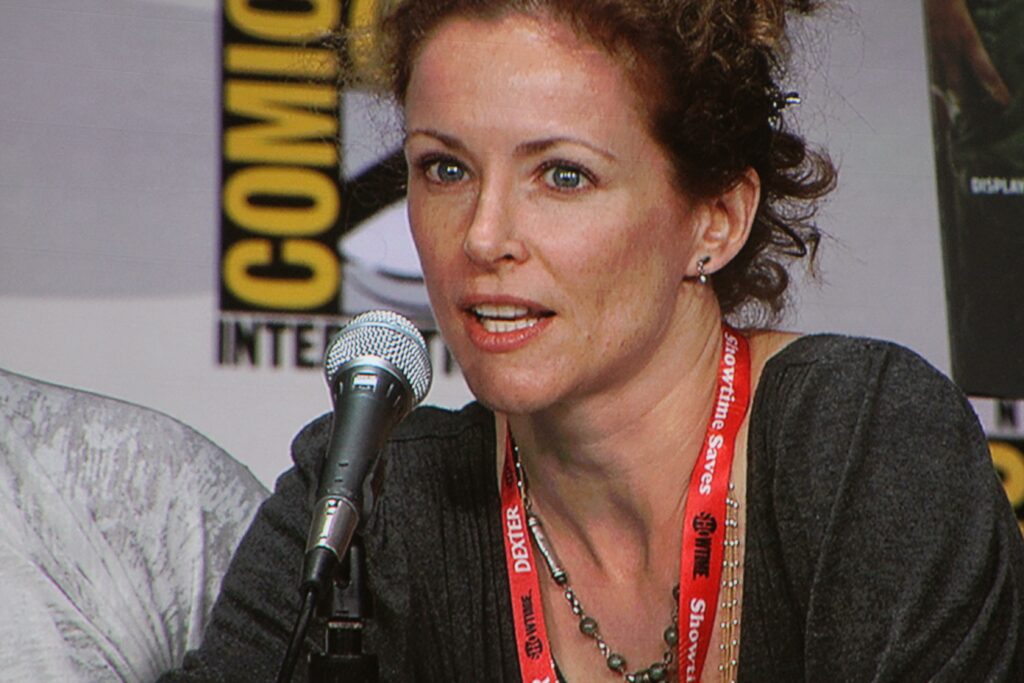 File:Leslie Hope at Comic-Con 2011.jpg - a woman with a microphone in front of a poster