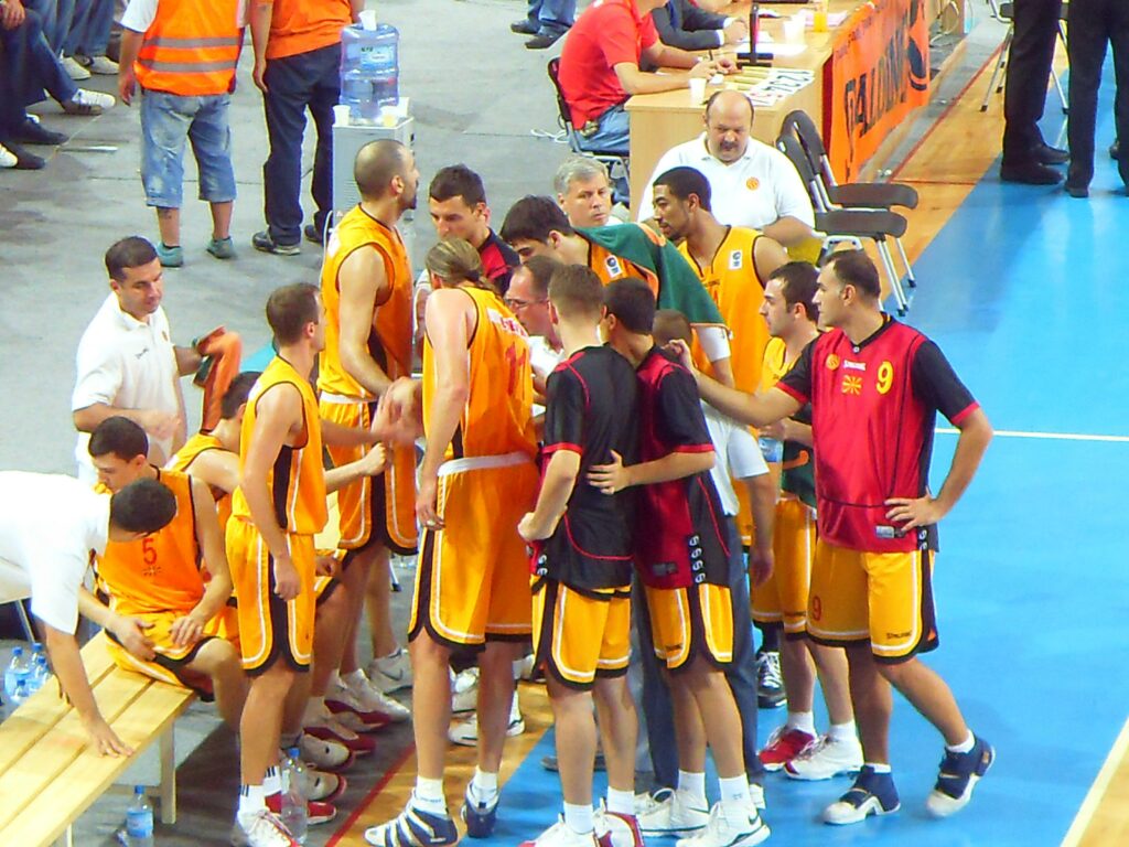 File:The Macedonian Basketball Team.JPG - a group of men standing around a bench