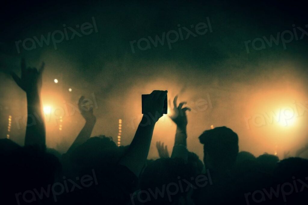 Free concert image - a crowd of people at a concert with their hands up