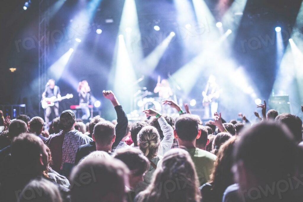 Free concert image - a crowd of people at a concert with their hands up