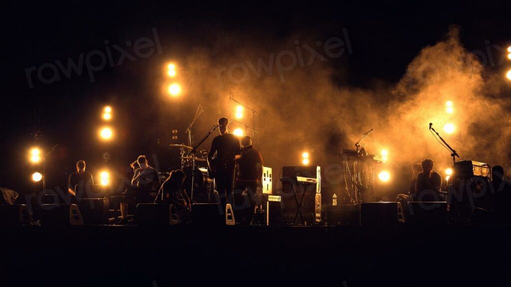 Group of people on a stage - a band performing on stage with a lot of smoke