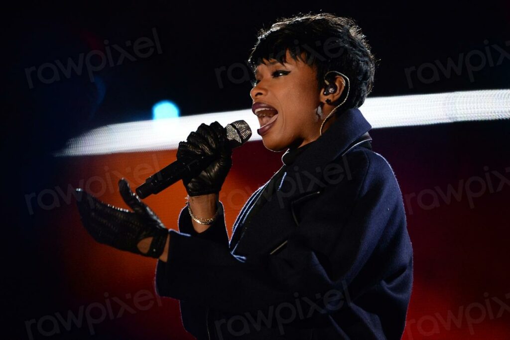 Jennifer Hudson sings the Star - a woman singing into a microphone