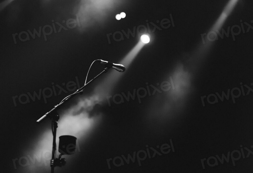 Microphone stage greyscale - a microphone on stage with spotlights in the background